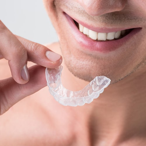 Man Smiling About To Put In Invisible Braces Invisalign True Orthodontics